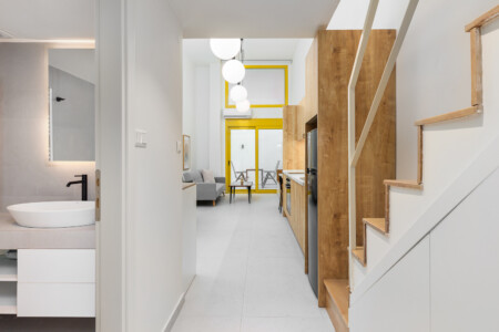 halu! Modern minimalist home interior featuring wooden staircase sleek kitchen with wooden elements spacious living area and bright lighting for a cozy atmosphere