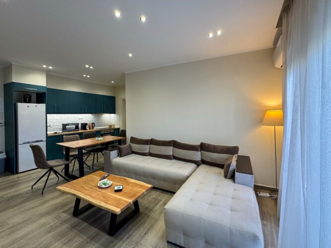 Modern one-bedroom apartment with stylish living room, fully equipped kitchen, terrace, and contemporary design for a comfortable stay in Moudania.