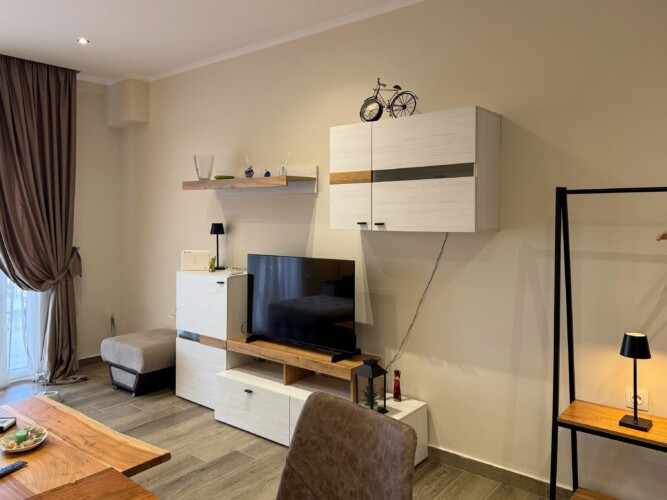 Modern one-bedroom apartment with stylish living room, fully equipped kitchen, terrace, and contemporary design for a comfortable stay in Moudania.