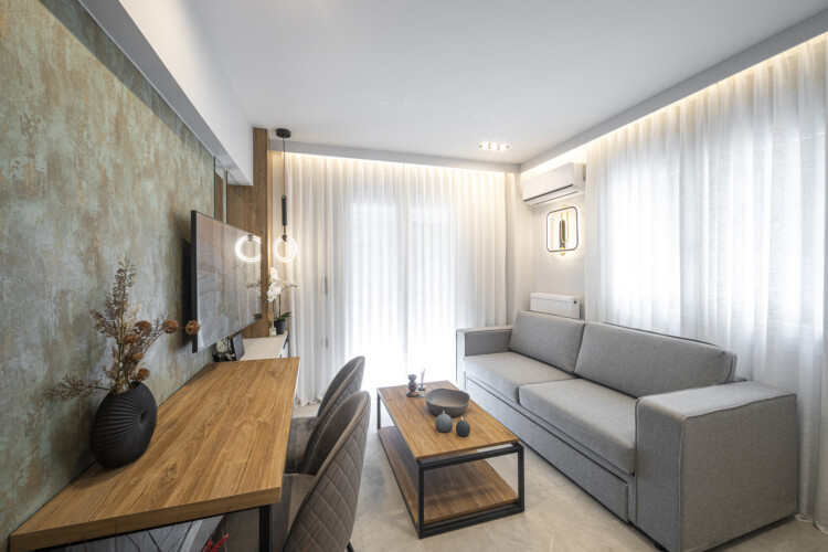 Modern one-bedroom apartment with stylish living room, fully equipped kitchen, private balcony, and contemporary design for a comfortable stay in Thessaloniki.