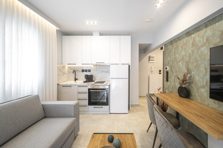 Modern one-bedroom apartment with stylish living room, fully equipped kitchen, private balcony, and contemporary design for a comfortable stay in Thessaloniki.