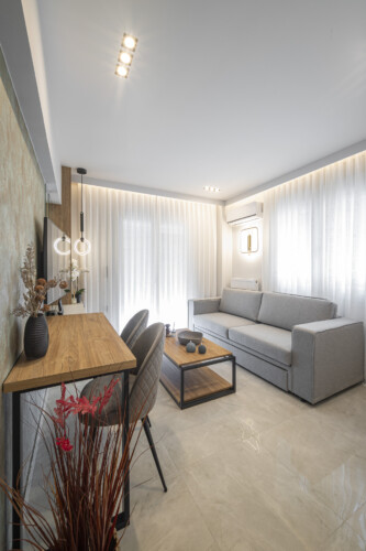 Modern one-bedroom apartment with stylish living room, fully equipped kitchen, private balcony, and contemporary design for a comfortable stay in Thessaloniki.