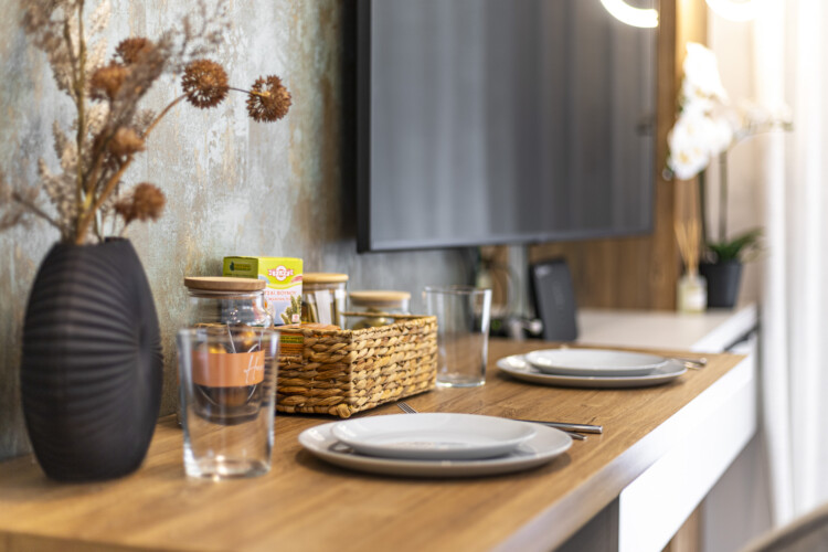 Modern one-bedroom apartment with stylish living room, fully equipped kitchen, private balcony, and contemporary design for a comfortable stay in Thessaloniki.