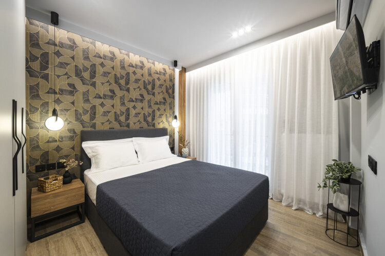 Modern one-bedroom apartment with stylish living room, fully equipped kitchen, private balcony, and contemporary design for a comfortable stay in Thessaloniki.