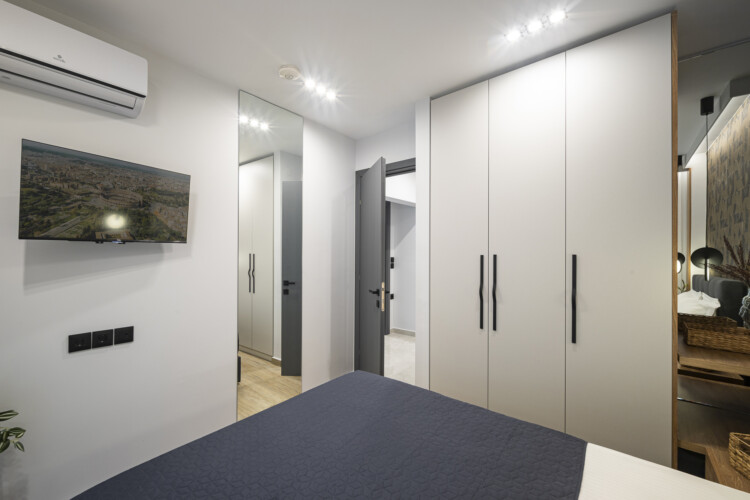 Modern one-bedroom apartment with stylish living room, fully equipped kitchen, private balcony, and contemporary design for a comfortable stay in Thessaloniki.