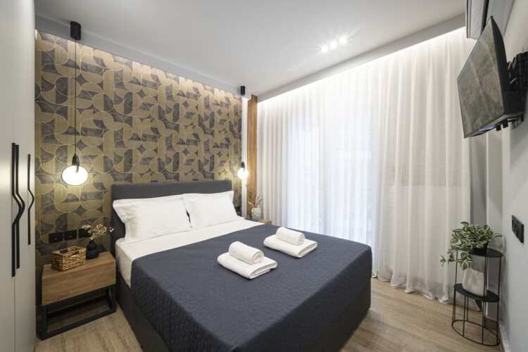 Modern one-bedroom apartment with stylish living room, fully equipped kitchen, private balcony, and contemporary design for a comfortable stay in Thessaloniki.