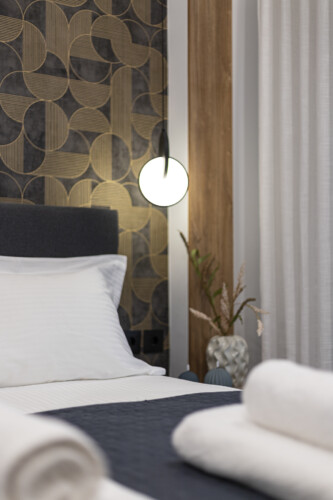 Modern one-bedroom apartment with stylish living room, fully equipped kitchen, private balcony, and contemporary design for a comfortable stay in Thessaloniki.