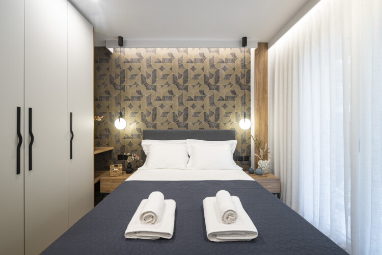 Modern one-bedroom apartment with stylish living room, fully equipped kitchen, private balcony, and contemporary design for a comfortable stay in Thessaloniki.