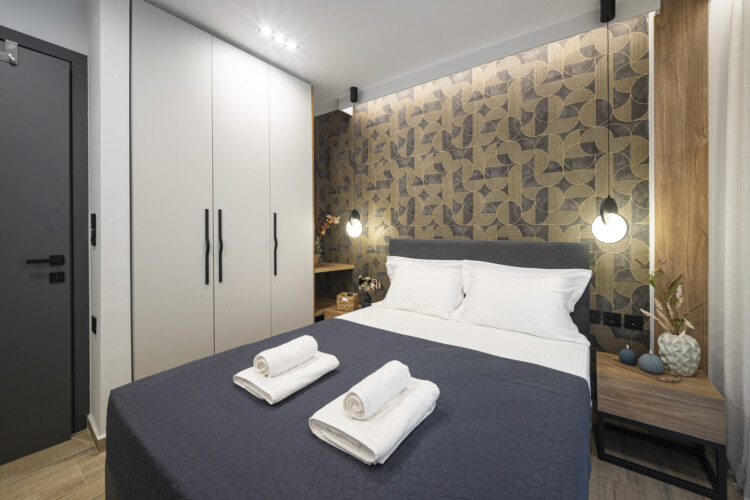 Modern one-bedroom apartment with stylish living room, fully equipped kitchen, private balcony, and contemporary design for a comfortable stay in Thessaloniki.