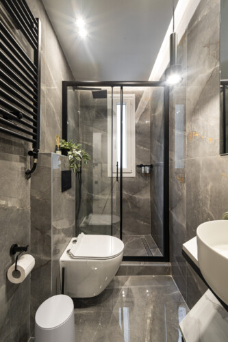 Modern one-bedroom apartment with stylish living room, fully equipped kitchen, private balcony, and contemporary design for a comfortable stay in Thessaloniki.