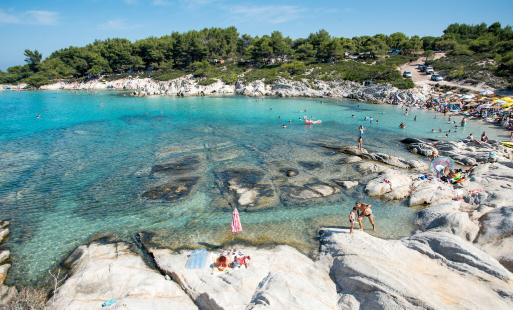 People swimming and relaxing at a beach. Kavourotripes rocky coast,