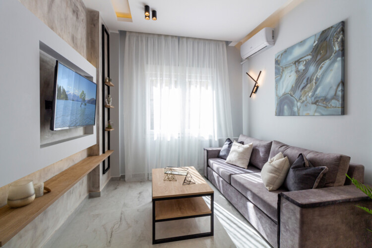 Modern two-bedroom apartment with stylish living room, fully equipped kitchen, balcony, and contemporary design for a comfortable stay in Thessaloniki.