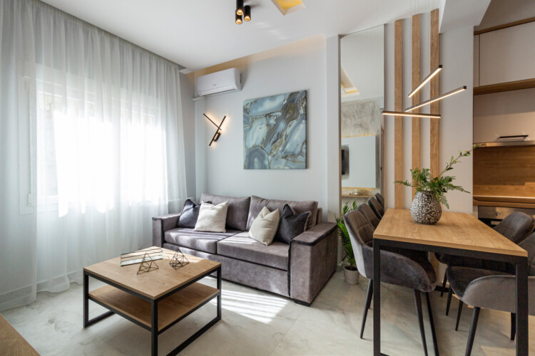Modern two-bedroom apartment with stylish living room, fully equipped kitchen, balcony, and contemporary design for a comfortable stay in Thessaloniki.
