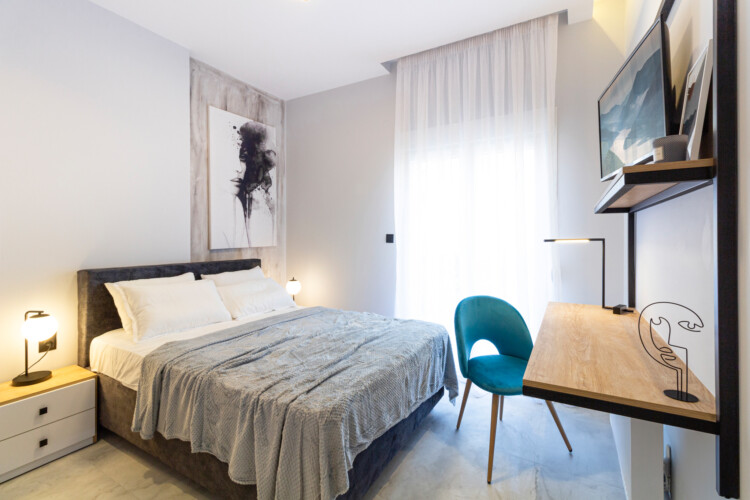 Modern two-bedroom apartment with stylish living room, fully equipped kitchen, balcony, and contemporary design for a comfortable stay in Thessaloniki.