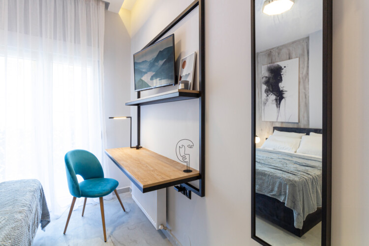 Modern two-bedroom apartment with stylish living room, fully equipped kitchen, balcony, and contemporary design for a comfortable stay in Thessaloniki.