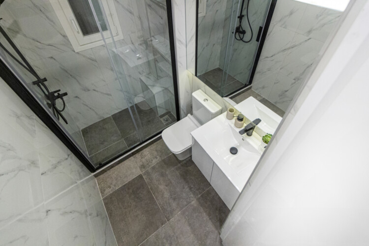 Modern two-bedroom apartment with stylish living room, fully equipped kitchen, balcony, and contemporary design for a comfortable stay in Thessaloniki.