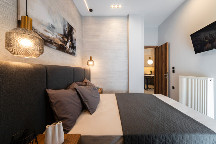 Modern two-bedroom apartment with stylish living room, fully equipped kitchen, balcony, and contemporary design for a comfortable stay in Thessaloniki.