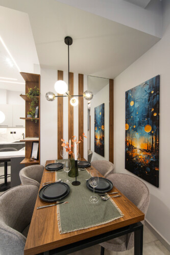 Modern two-bedroom apartment with stylish living room, fully equipped kitchen, balcony, and contemporary design for a comfortable stay in Thessaloniki.