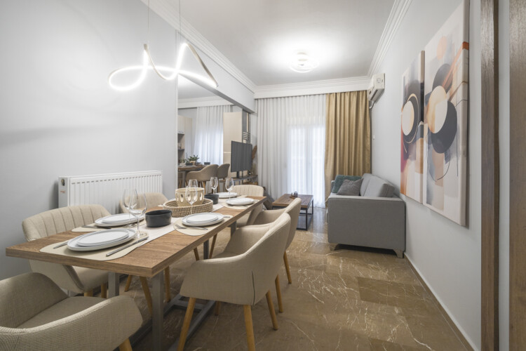 Modern three-bedroom apartment with stylish living room, fully equipped kitchen, balcony, and contemporary design for a comfortable stay in Thessaloniki.