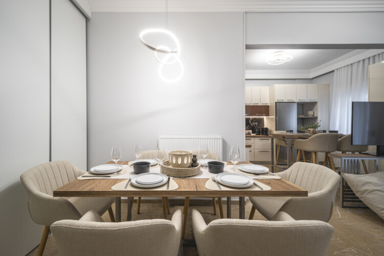 Modern three-bedroom apartment with stylish living room, fully equipped kitchen, balcony, and contemporary design for a comfortable stay in Thessaloniki.