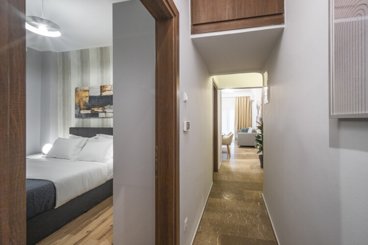 Modern three-bedroom apartment with stylish living room, fully equipped kitchen, balcony, and contemporary design for a comfortable stay in Thessaloniki.