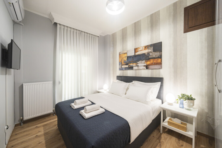 Modern three-bedroom apartment with stylish living room, fully equipped kitchen, balcony, and contemporary design for a comfortable stay in Thessaloniki.
