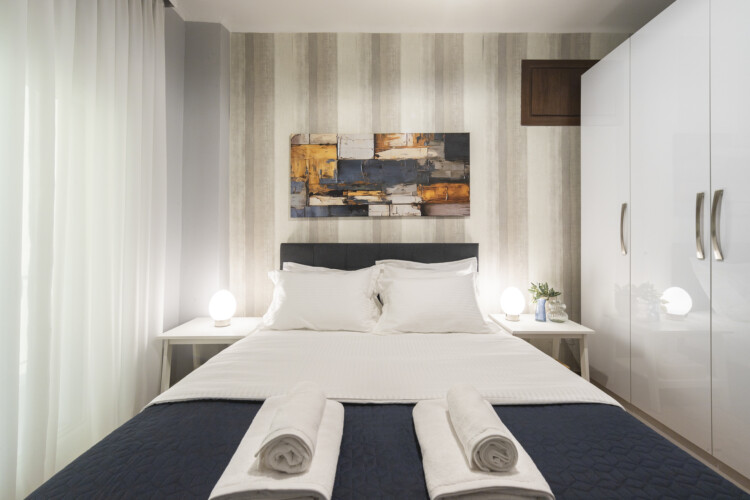 Modern three-bedroom apartment with stylish living room, fully equipped kitchen, balcony, and contemporary design for a comfortable stay in Thessaloniki.