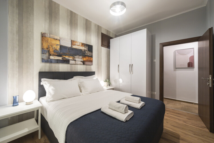 Modern three-bedroom apartment with stylish living room, fully equipped kitchen, balcony, and contemporary design for a comfortable stay in Thessaloniki.