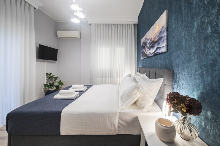 Modern three-bedroom apartment with stylish living room, fully equipped kitchen, balcony, and contemporary design for a comfortable stay in Thessaloniki.