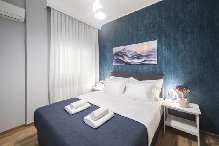 Modern three-bedroom apartment with stylish living room, fully equipped kitchen, balcony, and contemporary design for a comfortable stay in Thessaloniki.