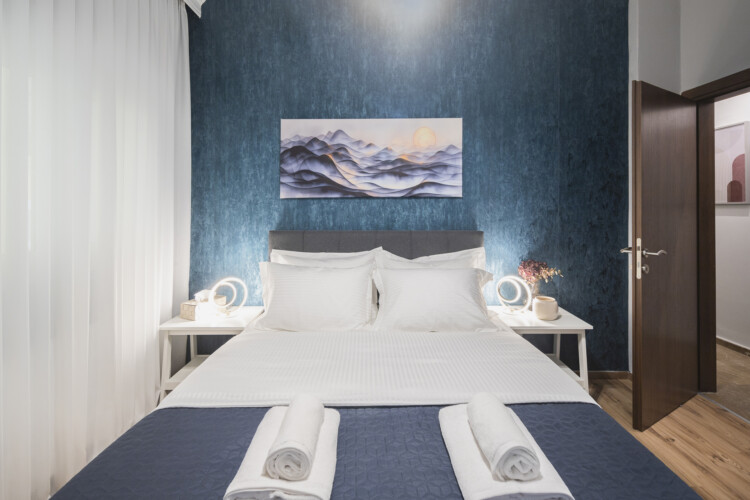 Modern three-bedroom apartment with stylish living room, fully equipped kitchen, balcony, and contemporary design for a comfortable stay in Thessaloniki.