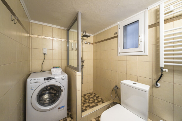 Modern three-bedroom apartment with stylish living room, fully equipped kitchen, balcony, and contemporary design for a comfortable stay in Thessaloniki.