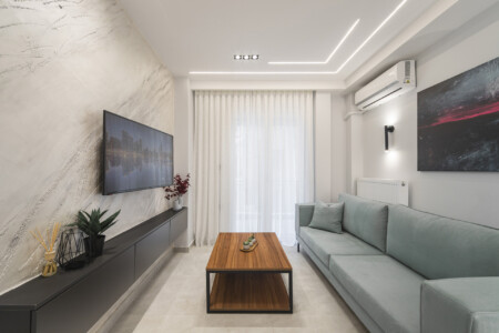Modern two-bedroom apartment with stylish living room, fully equipped kitchen, balcony, and contemporary design for a comfortable stay in Thessaloniki.