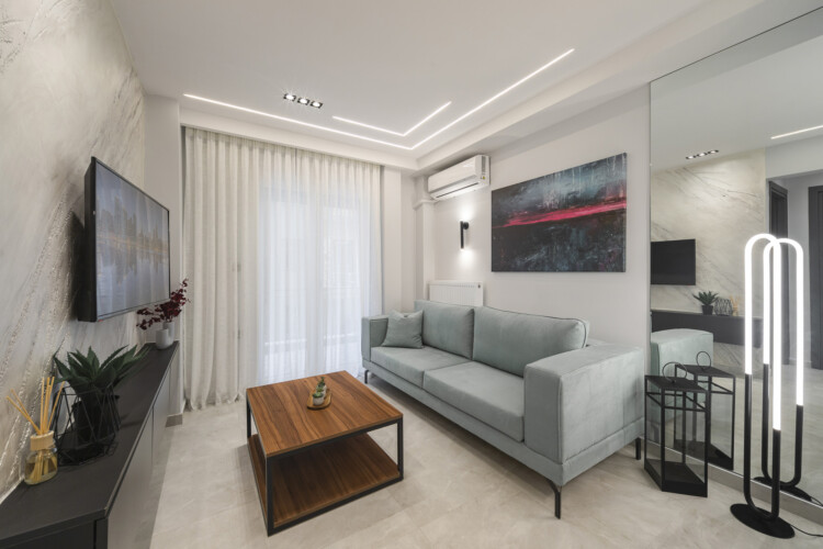 Modern two-bedroom apartment with stylish living room, fully equipped kitchen, balcony, and contemporary design for a comfortable stay in Thessaloniki.