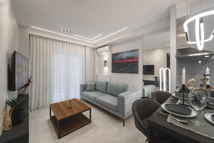 Modern two-bedroom apartment with stylish living room, fully equipped kitchen, balcony, and contemporary design for a comfortable stay in Thessaloniki.