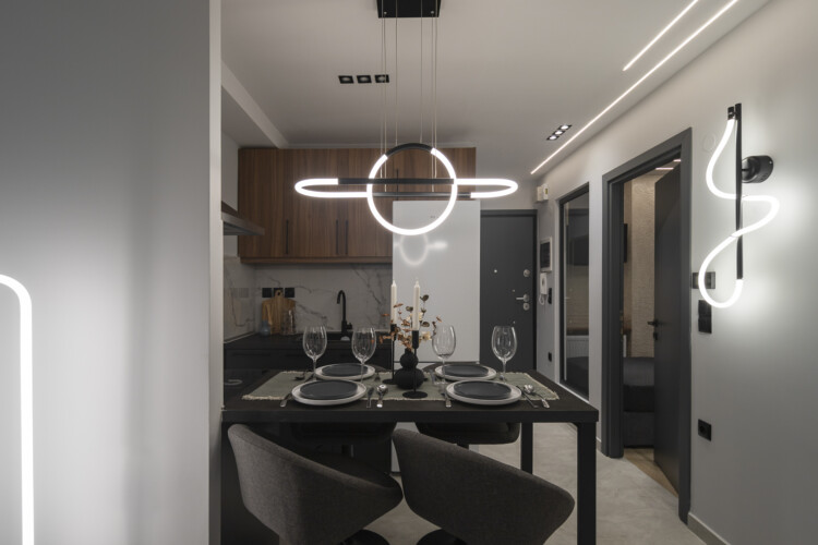 Modern two-bedroom apartment with stylish living room, fully equipped kitchen, balcony, and contemporary design for a comfortable stay in Thessaloniki.