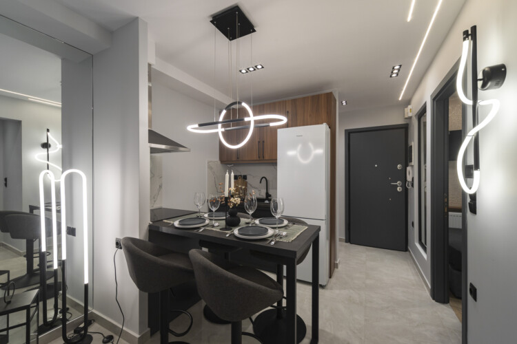 Modern two-bedroom apartment with stylish living room, fully equipped kitchen, balcony, and contemporary design for a comfortable stay in Thessaloniki.