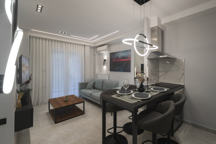 Modern two-bedroom apartment with stylish living room, fully equipped kitchen, balcony, and contemporary design for a comfortable stay in Thessaloniki.