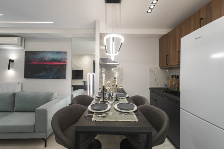 Modern two-bedroom apartment with stylish living room, fully equipped kitchen, balcony, and contemporary design for a comfortable stay in Thessaloniki.