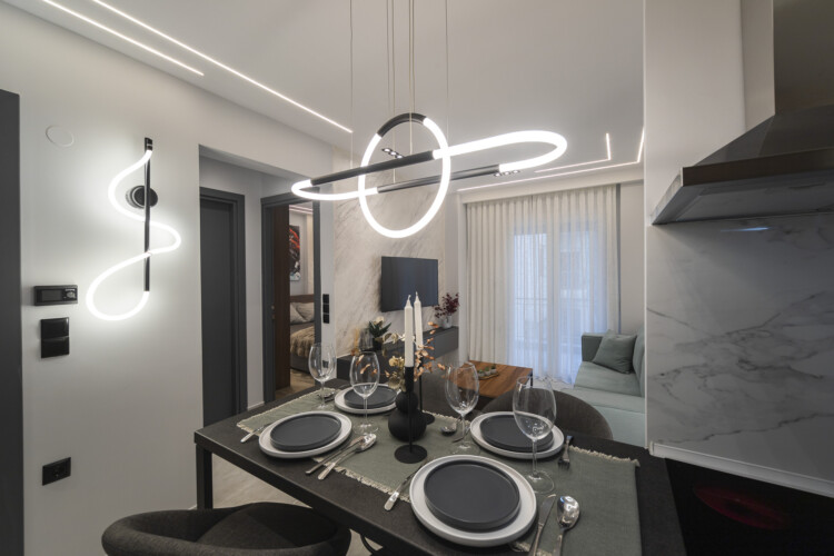 Modern two-bedroom apartment with stylish living room, fully equipped kitchen, balcony, and contemporary design for a comfortable stay in Thessaloniki.