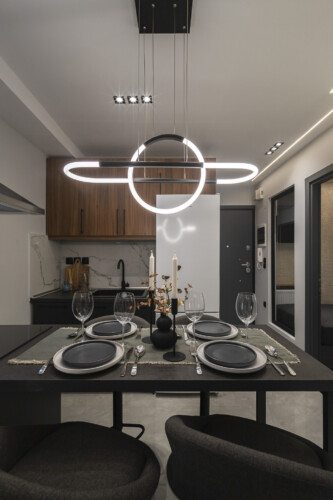 Modern two-bedroom apartment with stylish living room, fully equipped kitchen, balcony, and contemporary design for a comfortable stay in Thessaloniki.