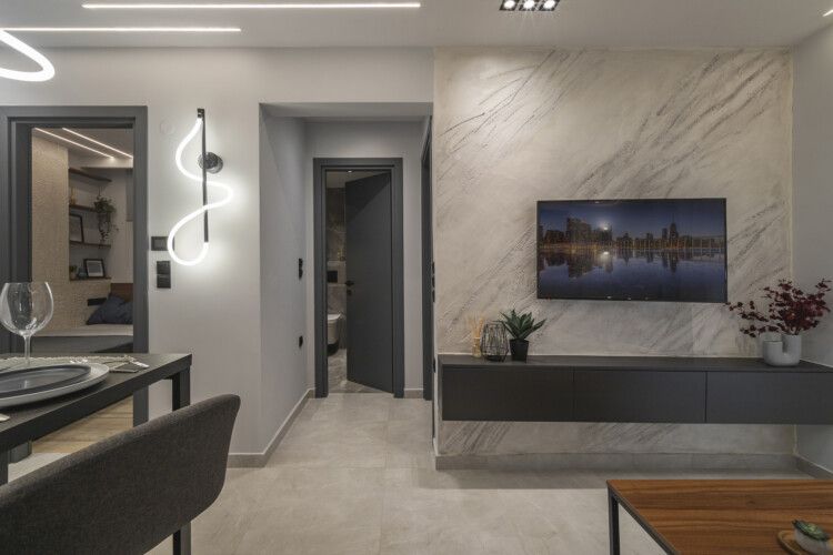 Modern two-bedroom apartment with stylish living room, fully equipped kitchen, balcony, and contemporary design for a comfortable stay in Thessaloniki.