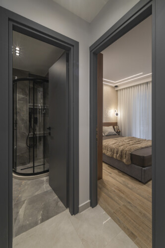 Modern two-bedroom apartment with stylish living room, fully equipped kitchen, balcony, and contemporary design for a comfortable stay in Thessaloniki.