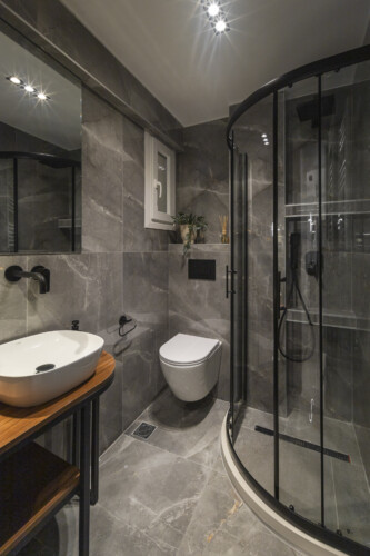 Modern two-bedroom apartment with stylish living room, fully equipped kitchen, balcony, and contemporary design for a comfortable stay in Thessaloniki.