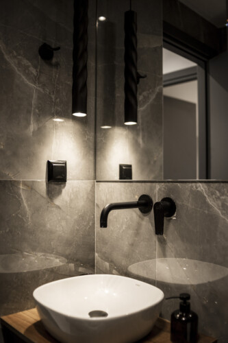 Modern two-bedroom apartment with stylish living room, fully equipped kitchen, balcony, and contemporary design for a comfortable stay in Thessaloniki.