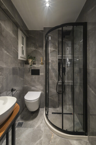 Modern two-bedroom apartment with stylish living room, fully equipped kitchen, balcony, and contemporary design for a comfortable stay in Thessaloniki.