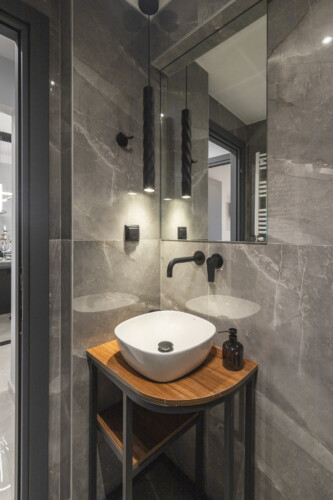 Modern two-bedroom apartment with stylish living room, fully equipped kitchen, balcony, and contemporary design for a comfortable stay in Thessaloniki.