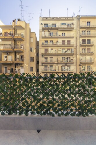 Modern two-bedroom apartment with stylish living room, fully equipped kitchen, balcony, and contemporary design for a comfortable stay in Thessaloniki.