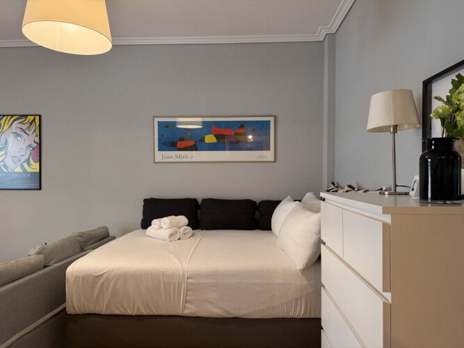 Modern one-bedroom apartment in the center of Thessaloniki with stylish living space, comfortable bed, and capacity for up to four guests.