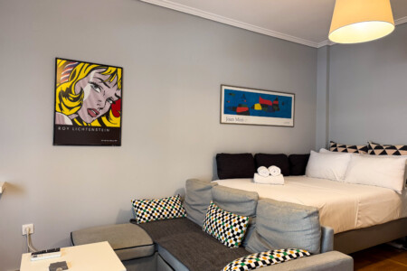 Modern one-bedroom apartment in the center of Thessaloniki with stylish living space, comfortable bed, and capacity for up to four guests.